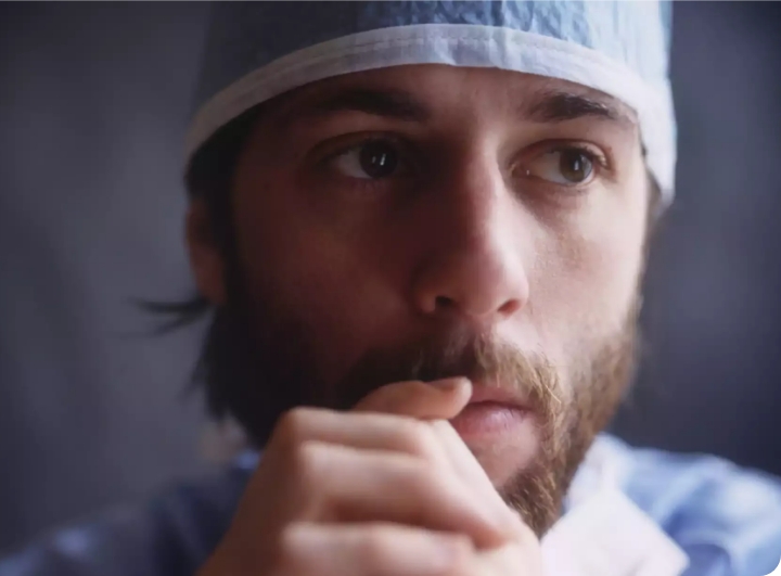 man in scrub cap looking pensive