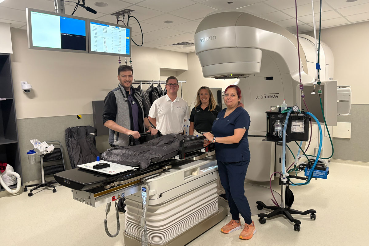 Veterinary therapists and CQ Medical representatives standing by Varian TrueBeam in a veterinarian treatment room