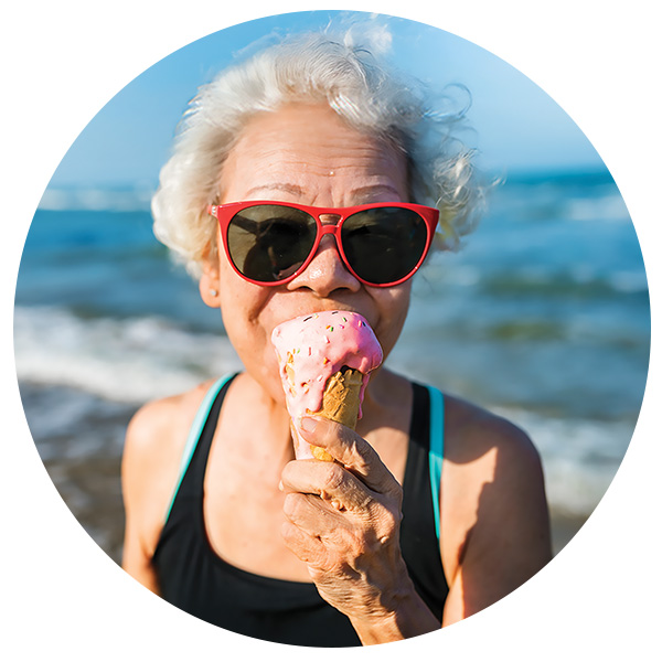 elderly woman with arthritis eating ice cream cone looking happy